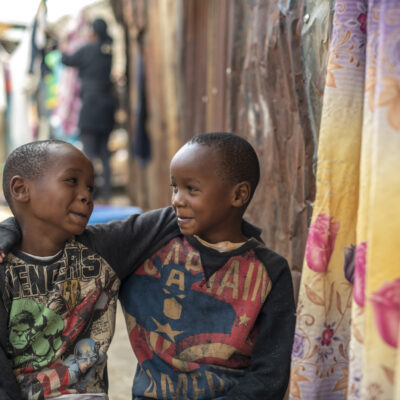 twee jongentjes uit kenia staan met armen over elkaars schouders